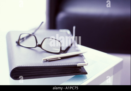Spectacles and diary on table Stock Photo