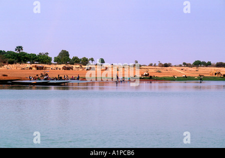 Boats line the river bank while people wash in Niger River near Timbuktu Mali Stock Photo