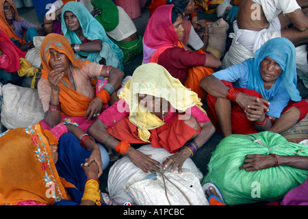 Women wearing colorful sarees wait at the New Delhi train station in India Stock Photo