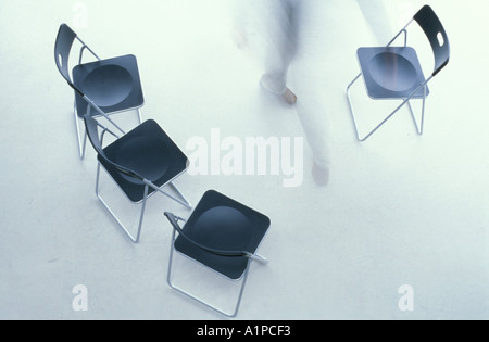 Man between chairs, elevated view Stock Photo