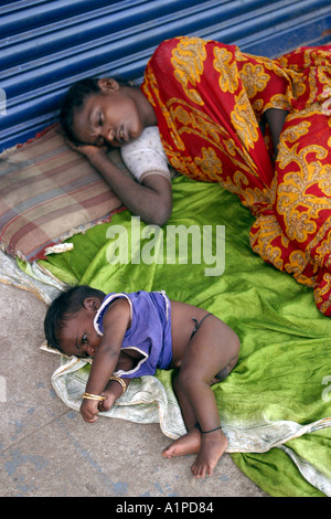 A homeless mother and her child sleep on a pavement in Chennai Madras in southern India Stock Photo