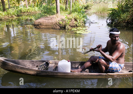 A man rowing his canoe down the river in Kerala India Stock Photo