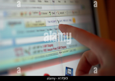 Finger pointing at cart on computer screen Stock Photo