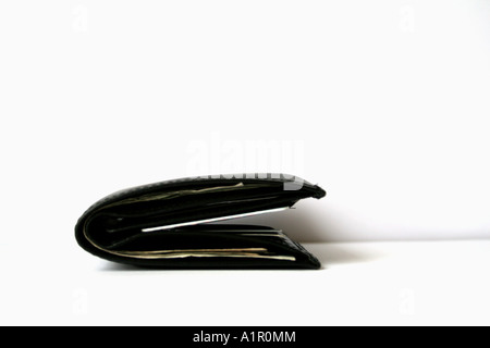 Folded black leather wallet on a white background representing simplicity and minimalism in everyday personal finance Stock Photo