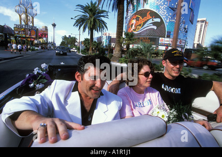 A couple renewing their vows and Elvis  impersonator travel the Las Vegas Strip in a  CadillacConvertible Las Vegas Nevada USA Stock Photo