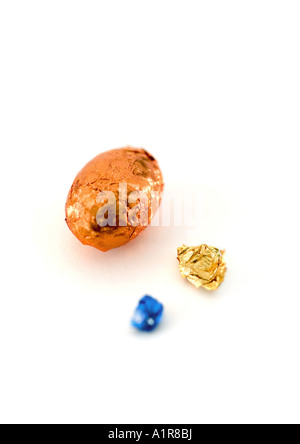 Wrapped easter egg and crumpled foil wrappers Stock Photo