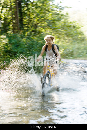 Mountain biker riding through water, motion