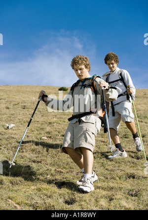 Two young men hiking down mountain Stock Photo