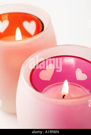 Lit candles in candleholder with heart pattern Stock Photo