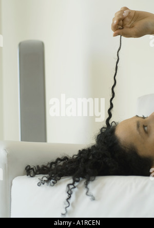 Woman pulling strand of hair Stock Photo