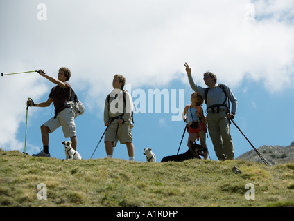 Hikers standing, looking at and pointing to view Stock Photo