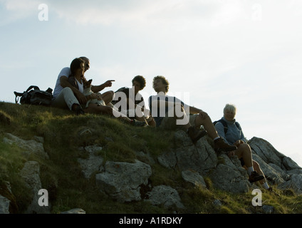 Hikers taking break, sitting on rocks Stock Photo