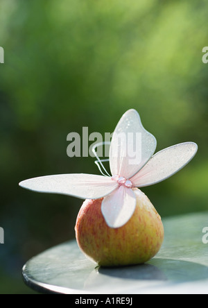 Fake butterfly on top of apple Stock Photo