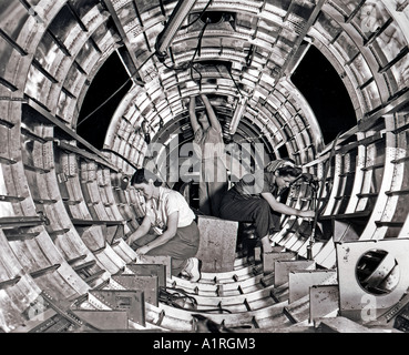 During WWII women worked in factories building such things as aircrafts These three women are working on a bomber Stock Photo