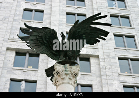 Eagle and Office: A bronze sculpture of an eagle with a backdrop of office windows set in a marble facade Federal Reserve Bank Stock Photo