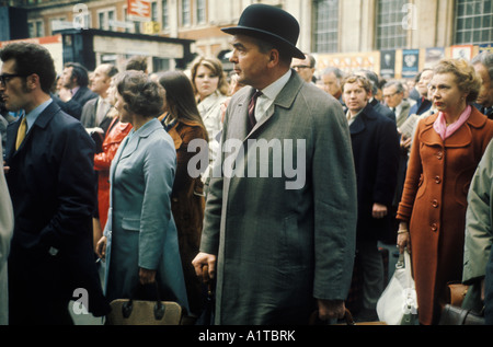London transport 1970s Waterloo main line railway train station 1972 City gent in bowler hat rolled umbrella crowds wait for late train UK HOMER SYKES Stock Photo