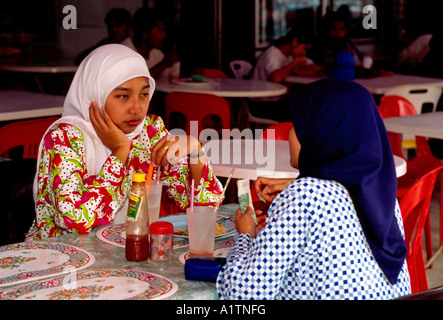 2, two, Malaysian women, Malaysians, Malay women, Malayan women, talking, eating at restaurant, Kuah, Langkawi Island, Kedah State, Malaysia, Asia Stock Photo