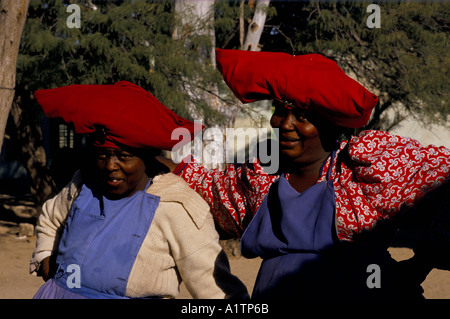 TWO HERERO WOMEN WEARING LARGE RED HATS NAMIBIA Stock Photo