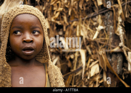 RWANDA.  REFUGEE CHILD FROM BURUNDI NEXT TO HUT MADE FROM LEAVES AND STICKS 1994 Stock Photo