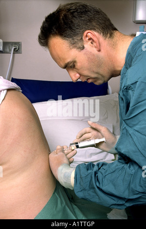 Epidural being given to a woman for pain relief during childbirth Stock Photo