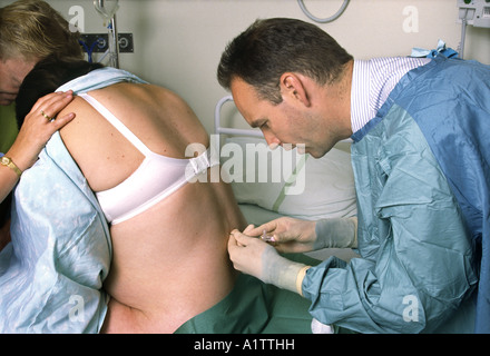 Epidural being given to a woman for pain relief during childbirth Stock Photo