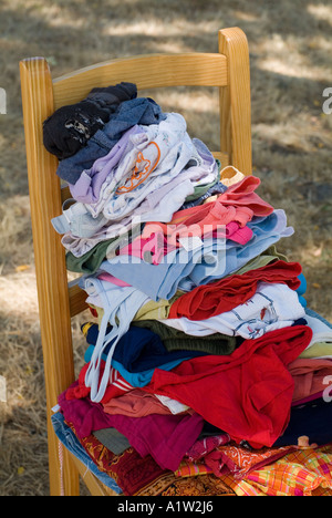 Stack of laundry on a chair in the backyard / garden. Stock Photo