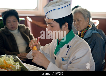 CHINA YANGTZE RIVER Chef demonstrates the art of vegetable carving by carving a carrot to look like a shrimp Stock Photo