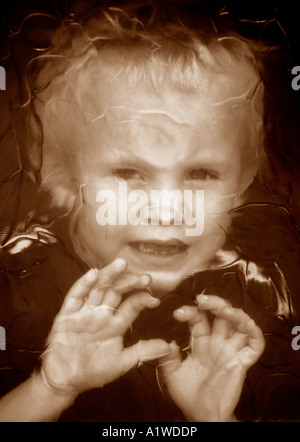 Little Boy Looking Through Patterned Glass Window. Stock Photo