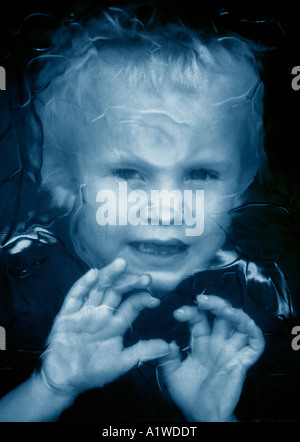 Little Boy Looking Through Patterned Glass Window. Stock Photo