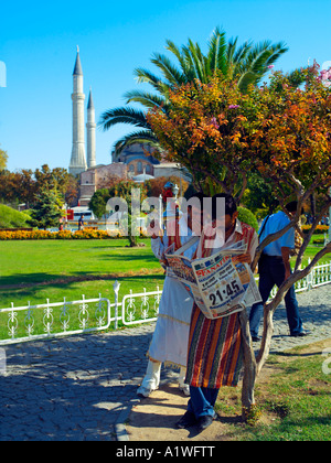 Drinks vendors reading the sport's paper in Istanbul's Sultanahmet Park Stock Photo