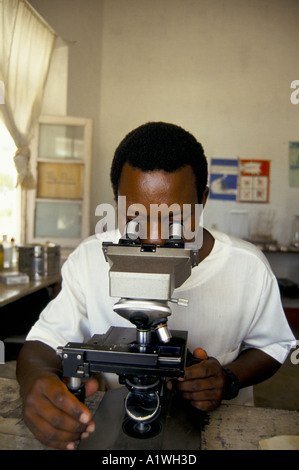 LOOKING THROUGH MICROSCOPE IN MAGANJA HOSPITAL MOZAMBIQUE 1993 Stock Photo