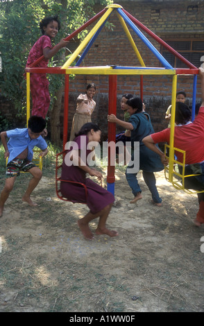 Residential school  and home for rescued circus children, Bhairawa,Nepal.   Playing on the roundabout. Stock Photo