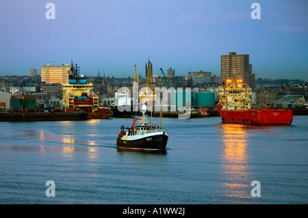 Aberdeen city harbour lights;  Herring fishing trawler leaving for open sea, Aberdeenshire Scotland, UK Stock Photo