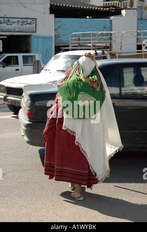 Old woman carrying bag on the street in Gabes city in Tunisia Stock Photo