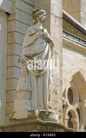 Statue standing outside the basilica de Notre Dame in the historic old town of Dole Stock Photo