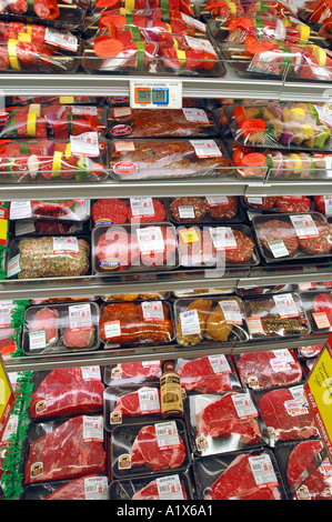 A meat case in a supermarket with fresh meats and beef steaks wrapped for sale Stock Photo