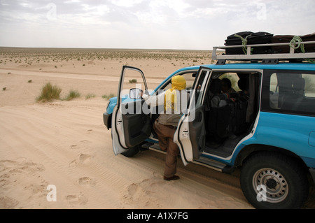 Crosscountry vehicle with tourists on the road, Sahara desert, Tunisia Stock Photo