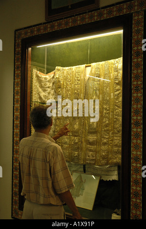 Man watching tunisian clothes in Dar Cherait Museum in Tozeur, Tunisia Stock Photo