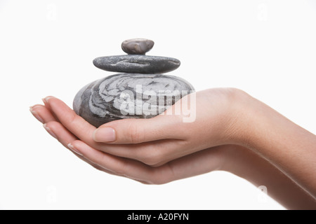 Woman holding pile of stones, close-up on hands Stock Photo