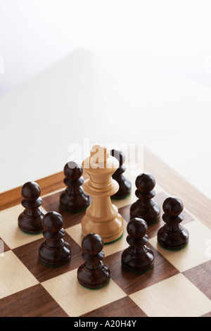 Chess game, white king surrounded by black pawns Stock Photo