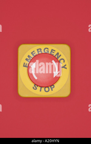 Emergency stop button on red background Stock Photo