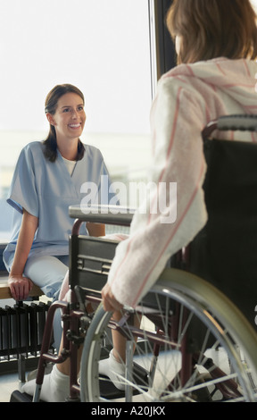 Physician Listening to Patient in wheelchair Stock Photo