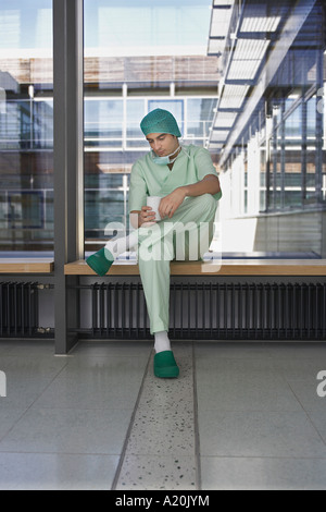 Pensive Physician having coffee in hospital corridor Stock Photo