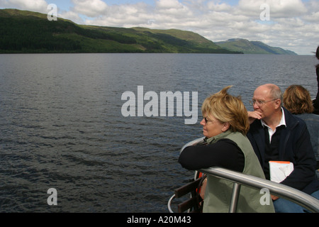 Tourists on a pleasure cruiser boat tour of Loch Ness keep an eye open for the Nessie the Loch Ness Monster, Scotland Stock Photo