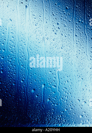 Water drops running down blue Glass Stock Photo