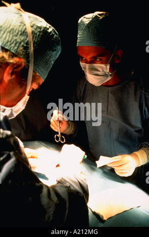 Two doctors wearing masks while operating on a patient Stock Photo