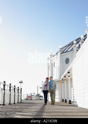 Couple holding hands, walking along pier Stock Photo
