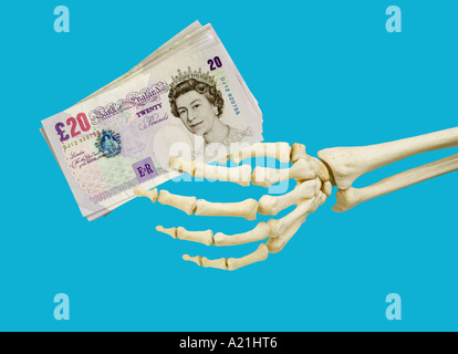 Human skeleton left hand holding British twenty 20 pound notes Stock Photo
