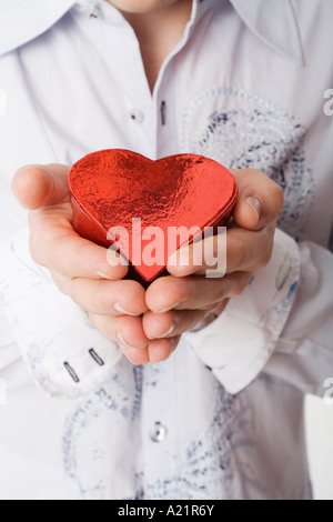 Man Holding Heart-Shaped Box Stock Photo