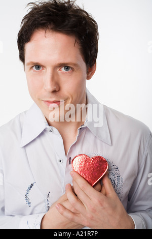 Man Holding Heart-Shaped Box Stock Photo